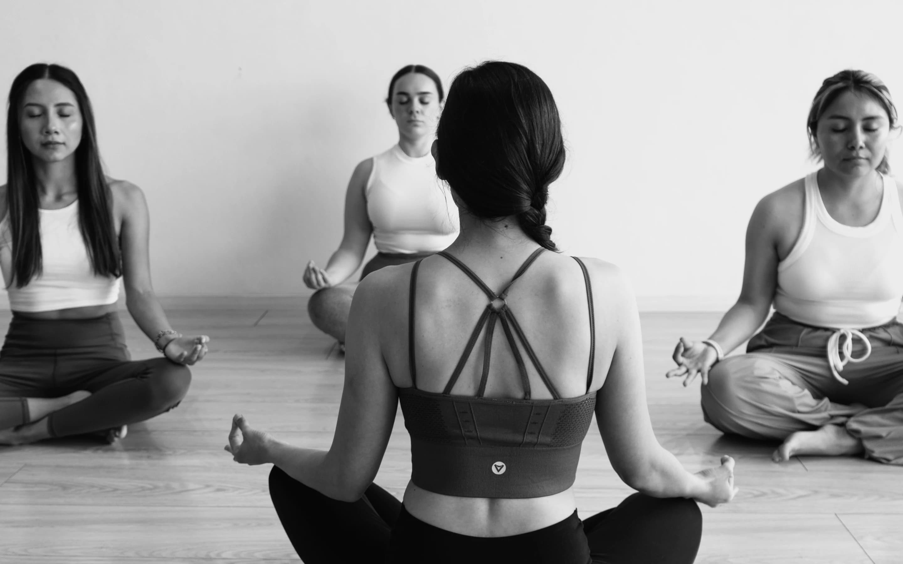 Un círculo de estudiantes meditando en el salón de Vitala
